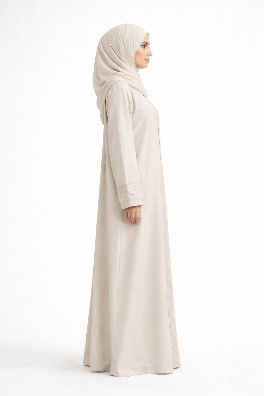 Cream Barbie & Reem style abaya with box collar and embroidered cuffs, angled side view (three-quarter profile).