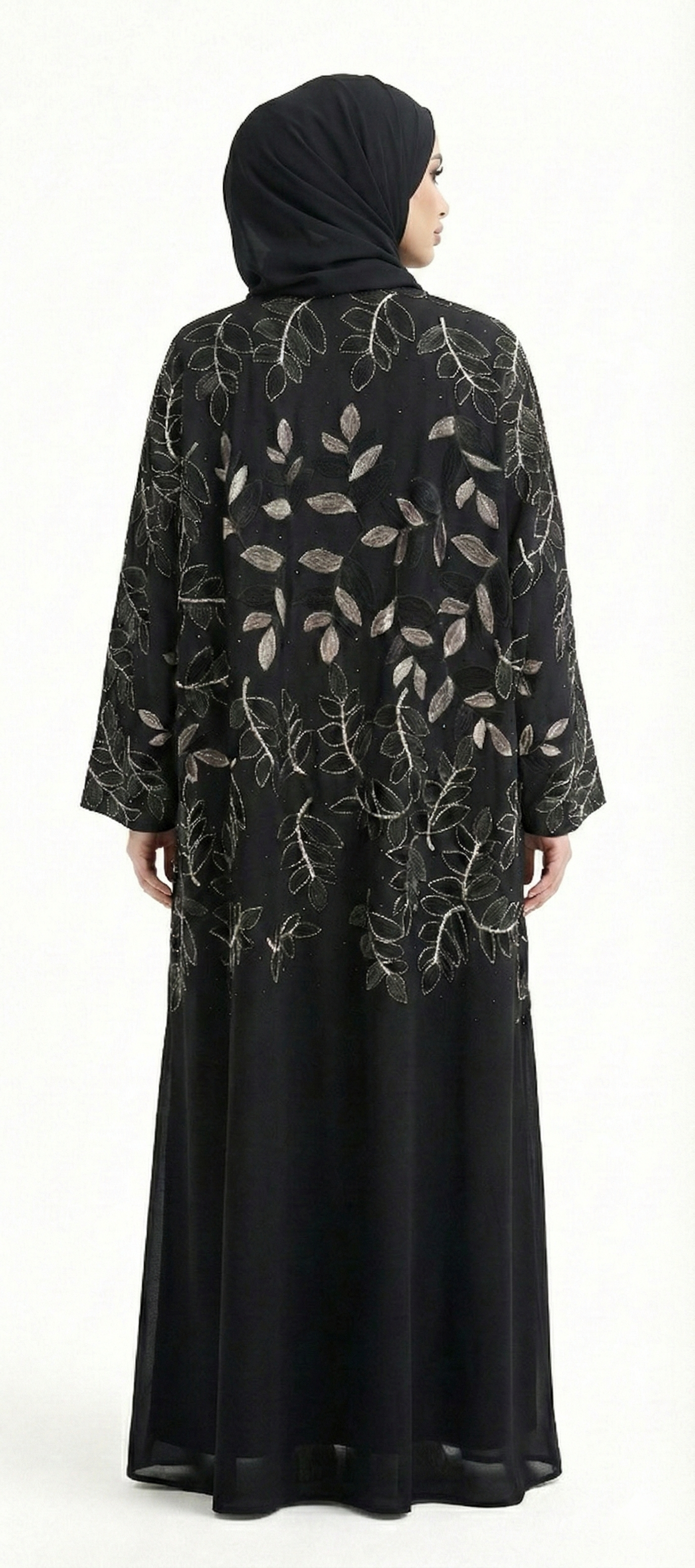 Back view of black abaya featuring gold leaf embroidery with black leaf detailing across the upper back, model wearing black hijab.