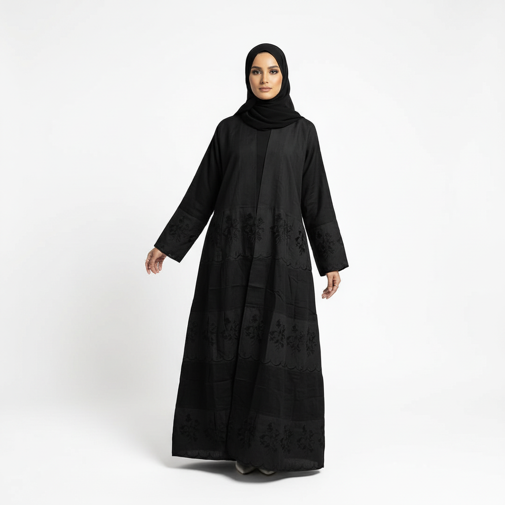 Black Hana layered crepe abaya shown with arms slightly out to display drape and embroidered panel detail, matching black hijab.