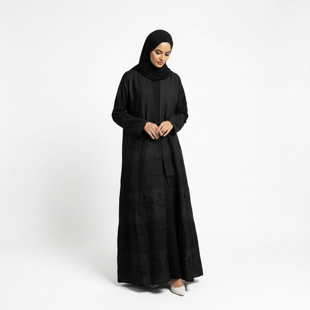 Front pose looking down in black Hana layered crepe abaya with subtle floral embroidery texture, matching black hijab.