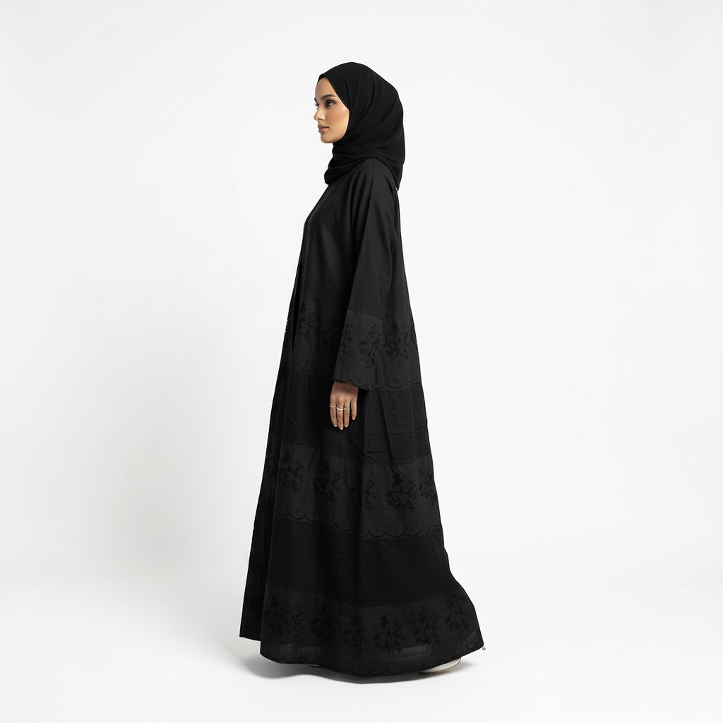 Side profile of black Hana layered crepe abaya showing long, flowing silhouette and subtle embroidery, matching black hijab.