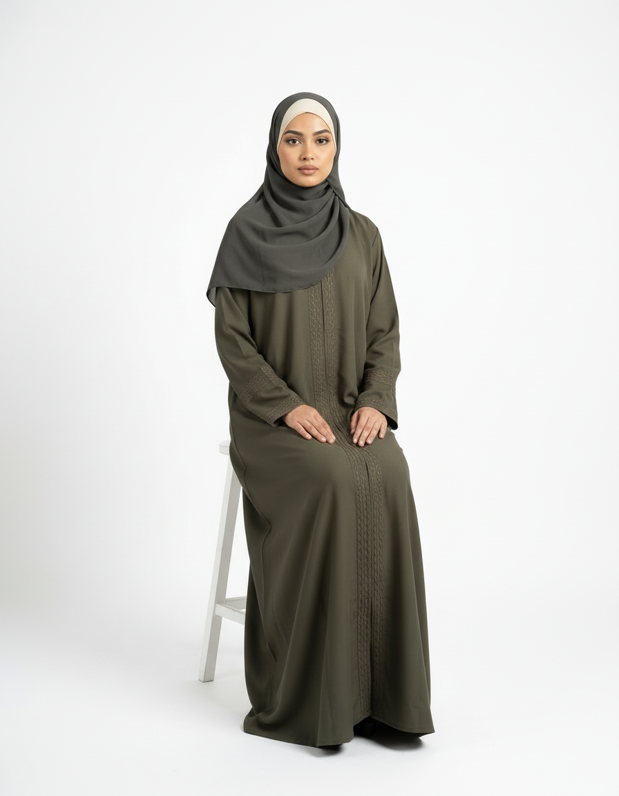 Seated front view of olive green Barbie & Reem style abaya showing full-length drape and cuff detail.