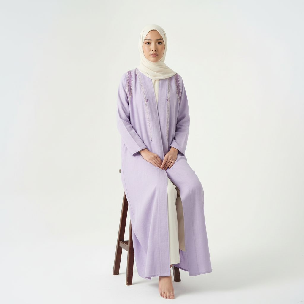 Purple linen thread-embroidered abaya with cream hijab, seated on stool (front view).