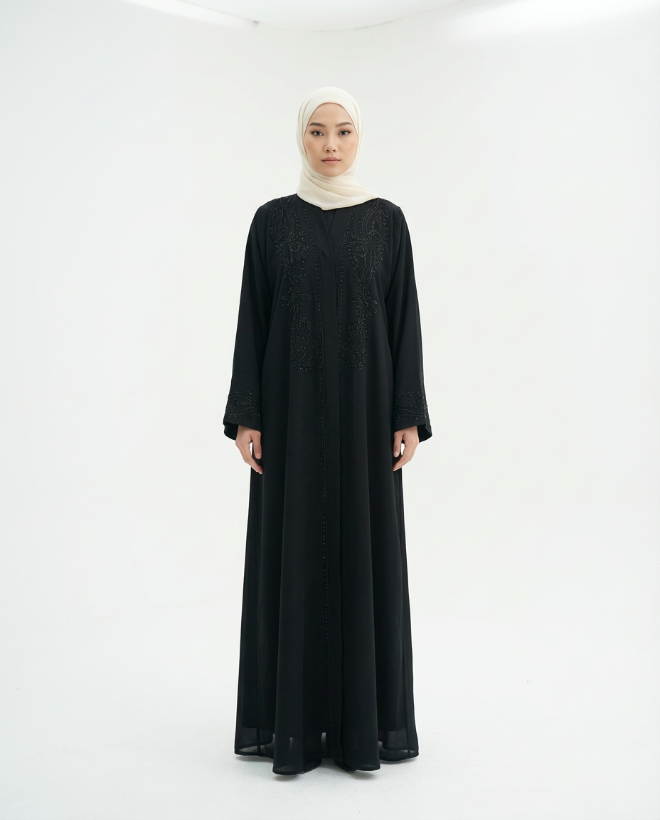 Full-length front view of a black abaya on a model wearing a cream hijab, studio white background.