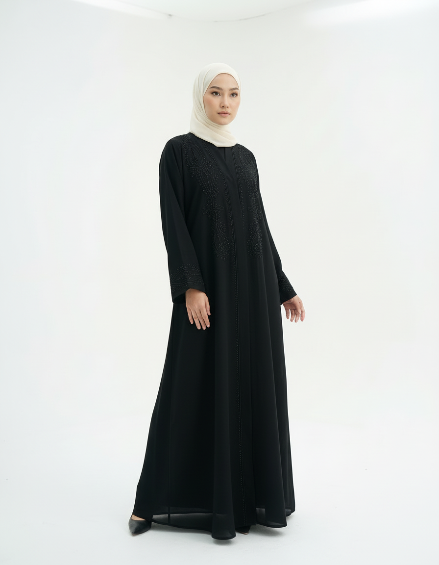 Slight angled front view showing the abaya’s flow and shape, model in cream hijab, studio white background.