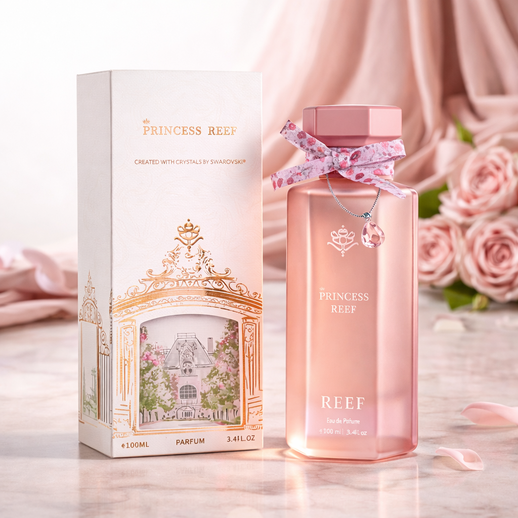 Princess Reef perfume with box and bottle in soft pink luxury setting with roses and fabric.